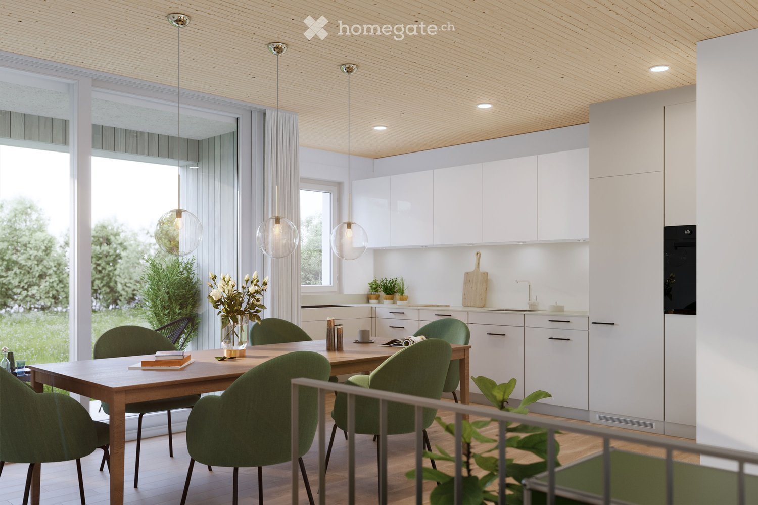 The image shows a modern, open-concept kitchen and dining area. The kitchen features white cabinets and drawers, a wooden countertop, and a built-in dishwasher. The dining area has a wooden table with green upholstered chairs, and three pendant lights han