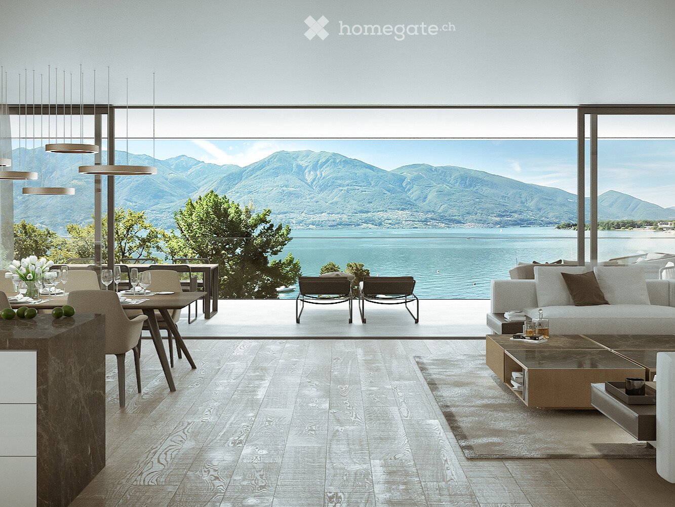 Spacious open-plan living area with large windows offering a stunning view of the mountains and lake. The room features a dining table, comfortable seating, and a modern, minimalist design.