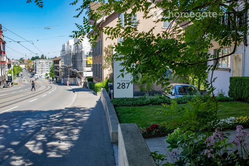 Urban residential area with well-manicured lawn and road infrastructure.