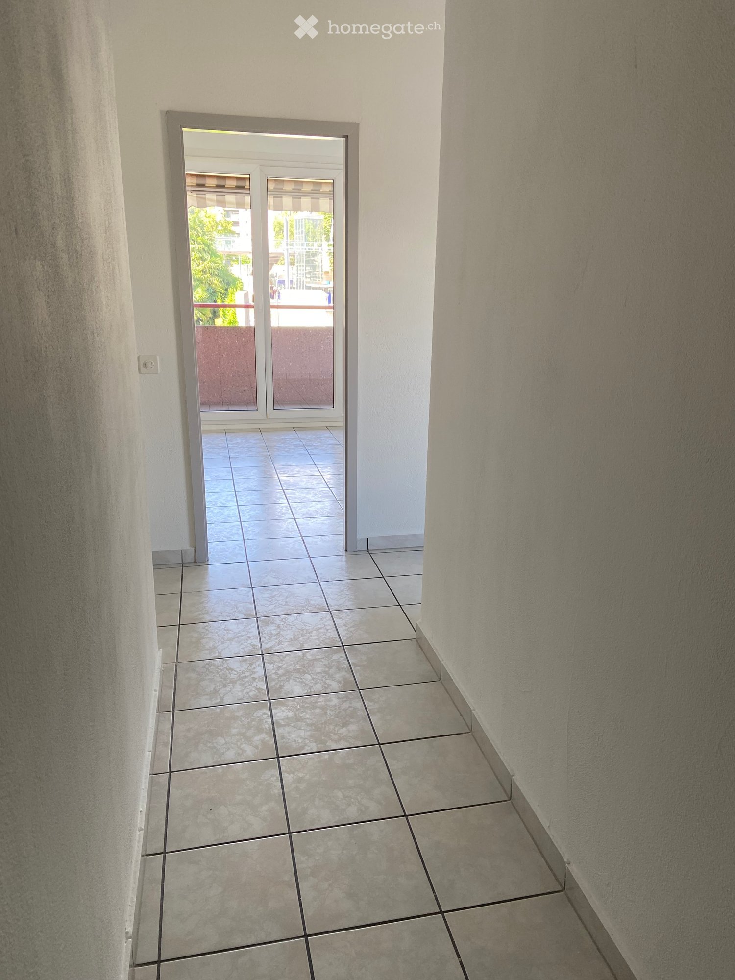 tiled floor, white walls, open doorway, balcony view