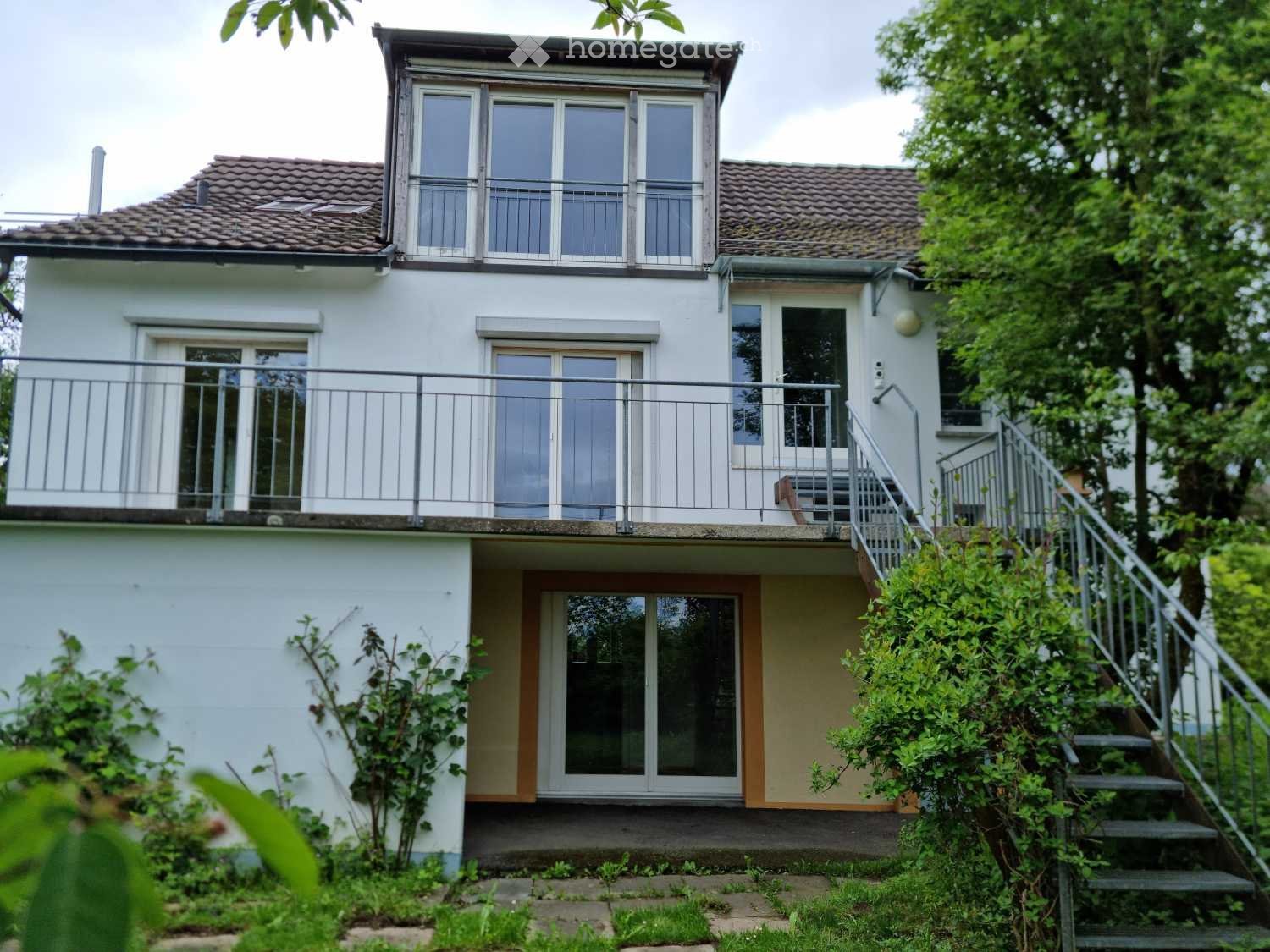 white house, brown roof, large balcony, double glass doors, stairs
