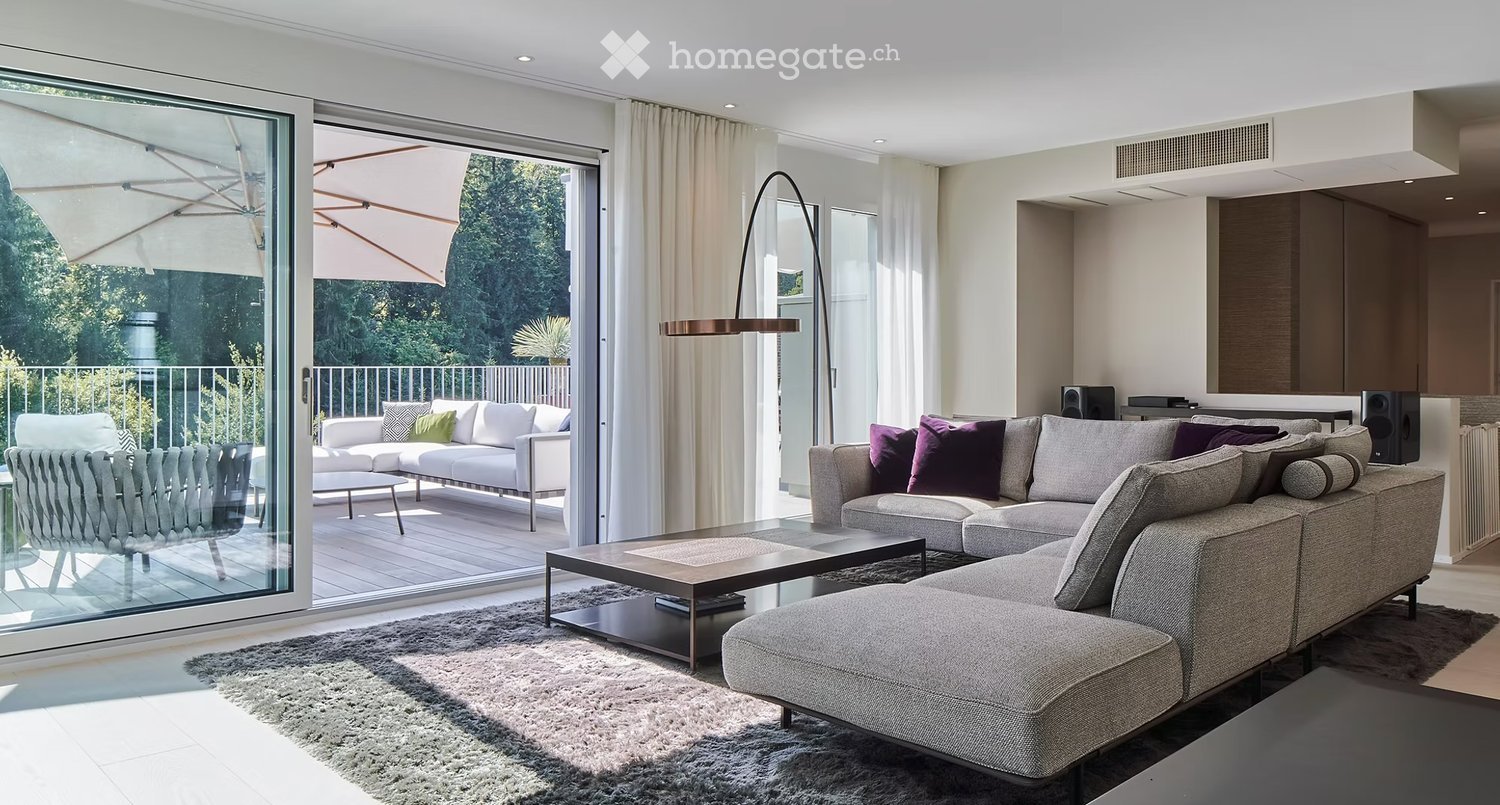 Sliding glass doors opening to a balcony, large sectional couch, coffee table, living room