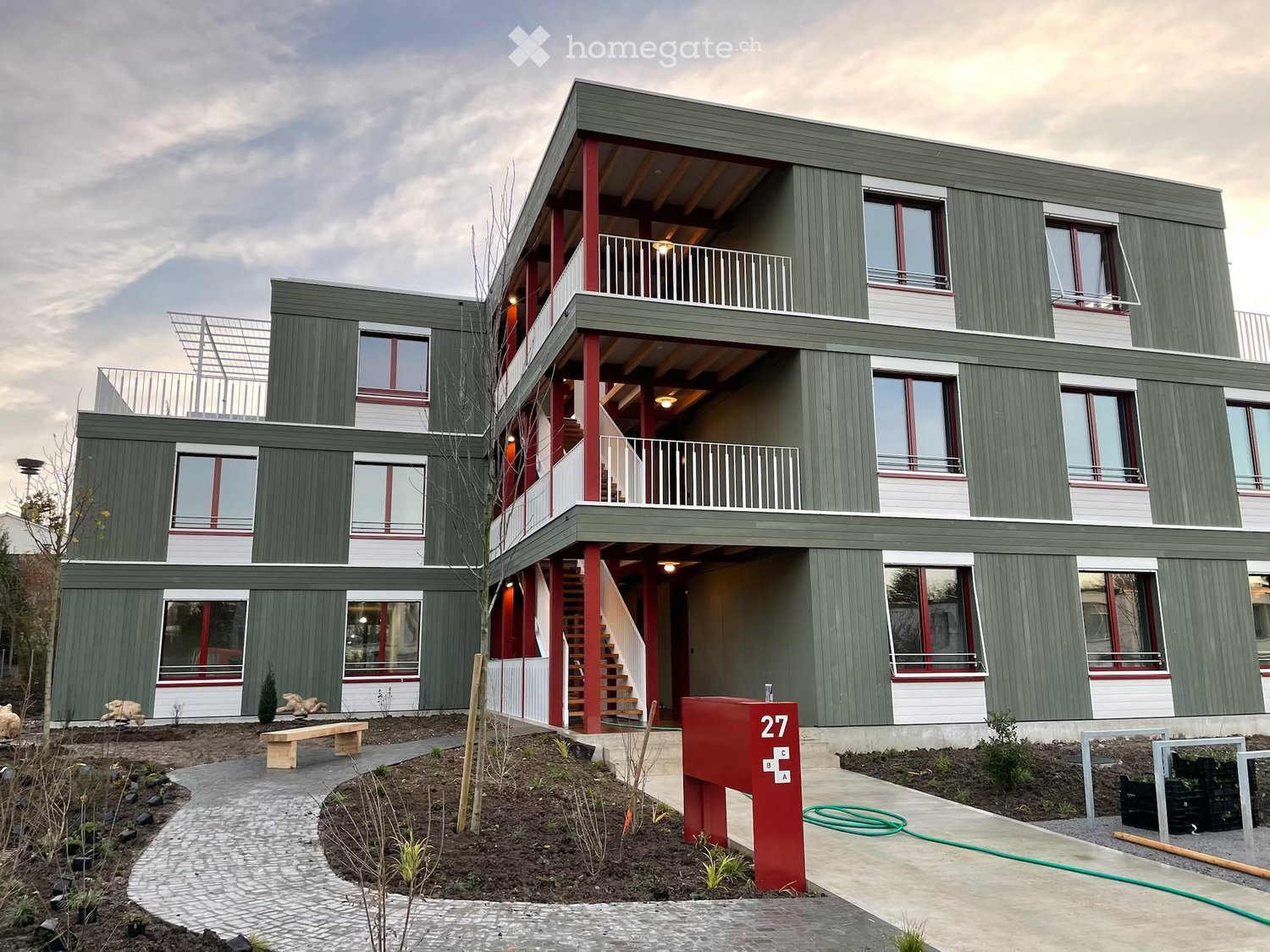 3 story house, green panels, red trim, balcony, red mailbox