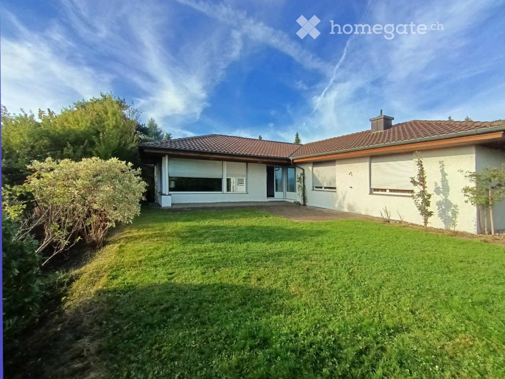 white house with tiled roof, single story, large lawn, large windows, garage