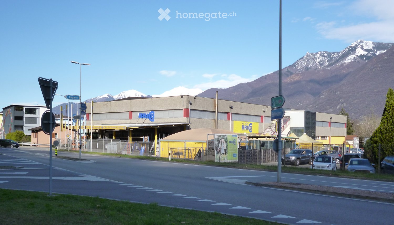 A building named BRICO, with parking space and cars in front of the building
