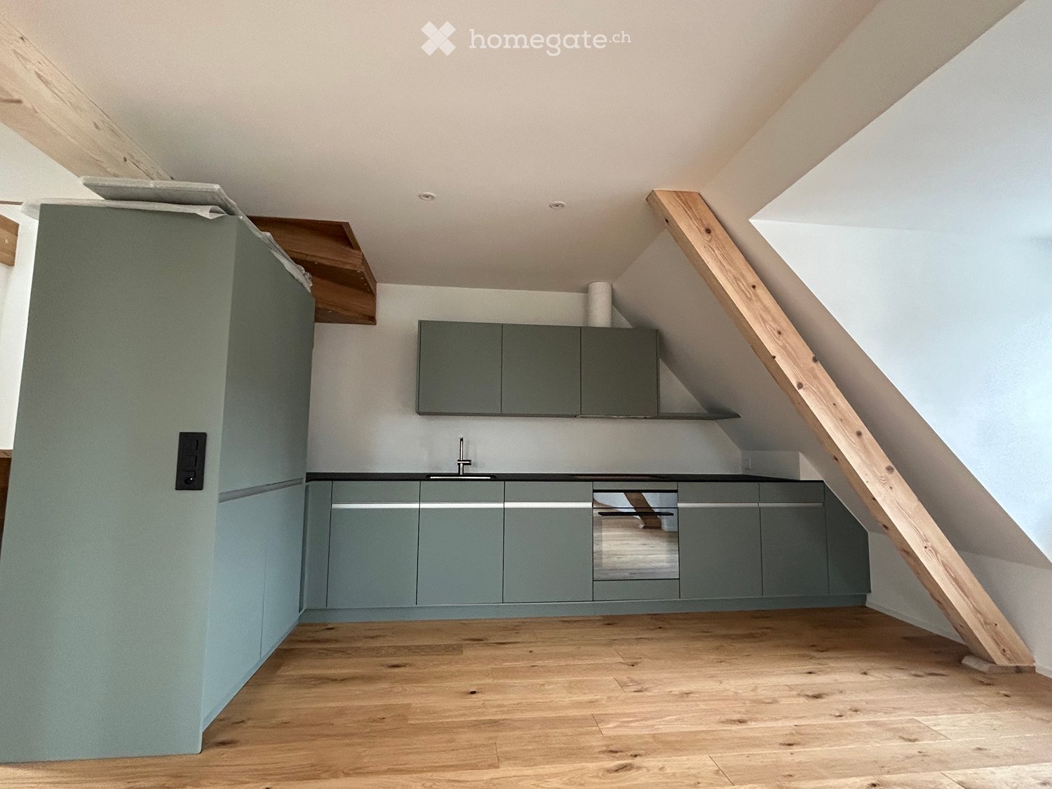 kitchen with wooden floor, white ceiling, wooden beams, green cabinets, stainless steel sink and oven