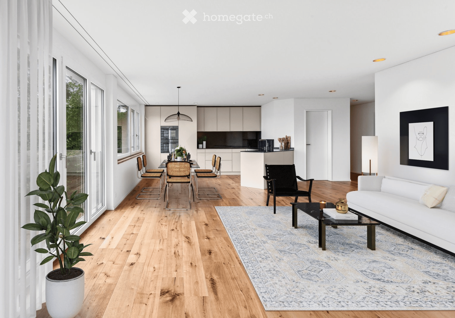 Modern interior with wooden floors, a dining table, a white couch, a coffee table, a white potted plant, a kitchen with white cabinets and an island with a sink, a pendant light hanging from the ceiling, white walls, large windows with white curtains