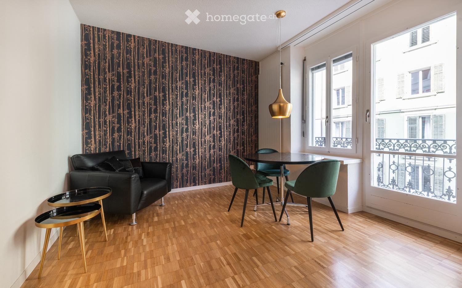 black couch, dining table with chairs, wallpaper, balcony, pendant light, view of a building