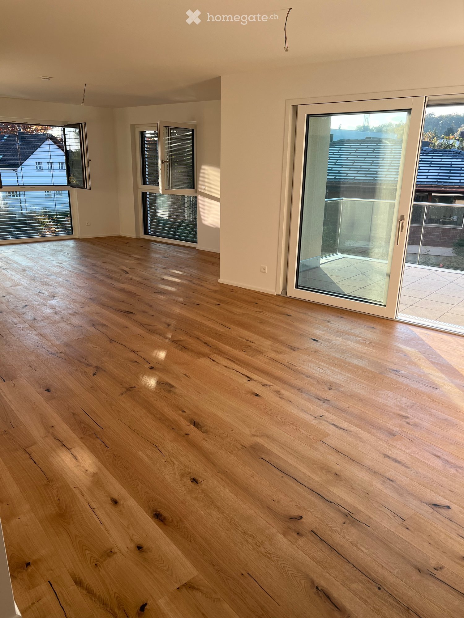 open floor plan, large windows, balcony, wooden floors