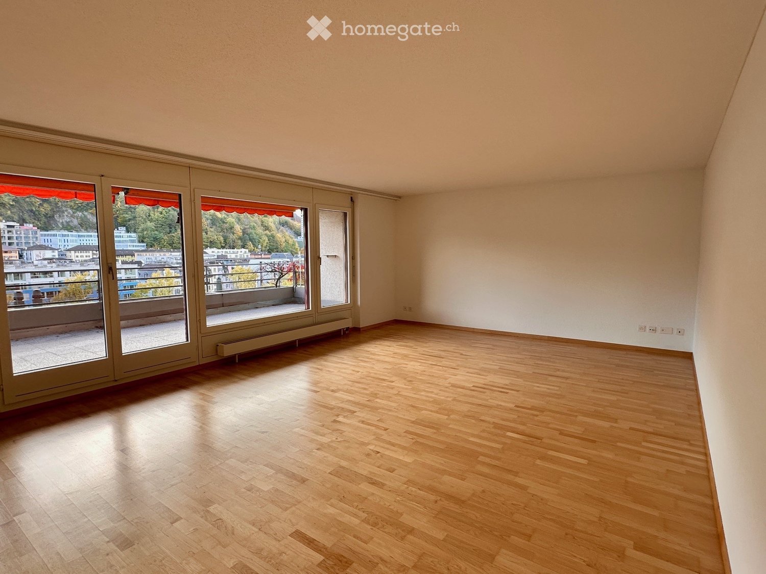 empty room, wooden floor, sliding glass doors leading to balcony, radiator, windows