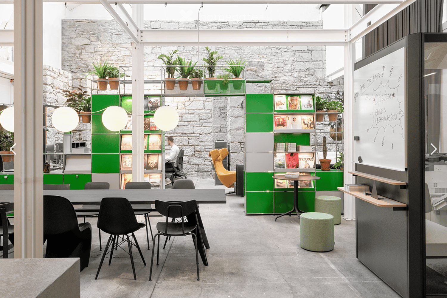 office space, green cabinets, stone wall, plants, round tables, swivel chairs, yellow chair, white board, stools