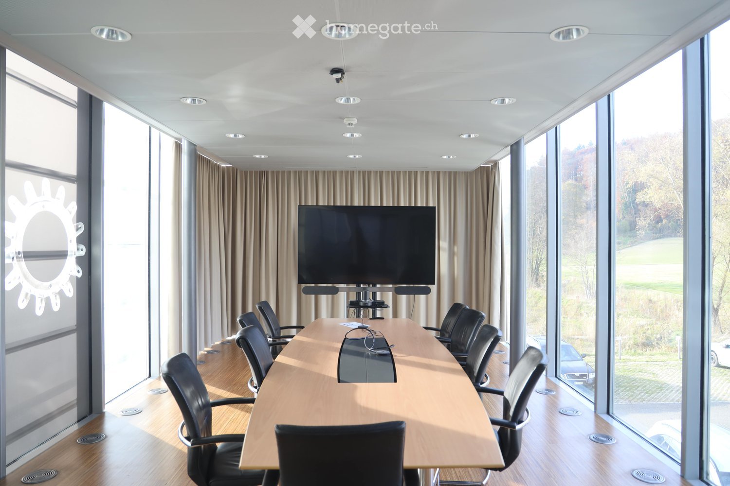 empty conference room, large glass windows, black chairs, table, TV, curtains