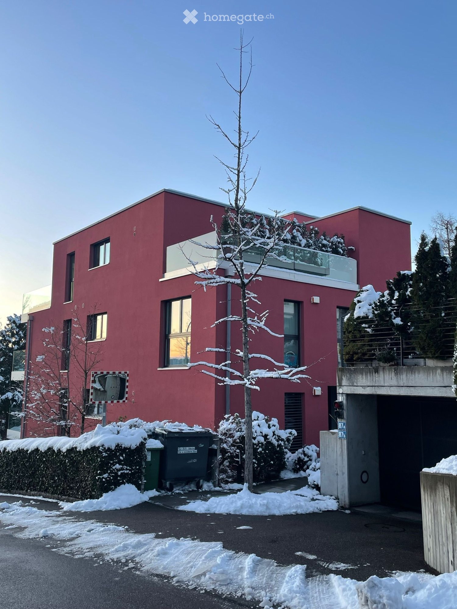 3-story modern apartment building, red, glass windows, balcony with railings, underground garage