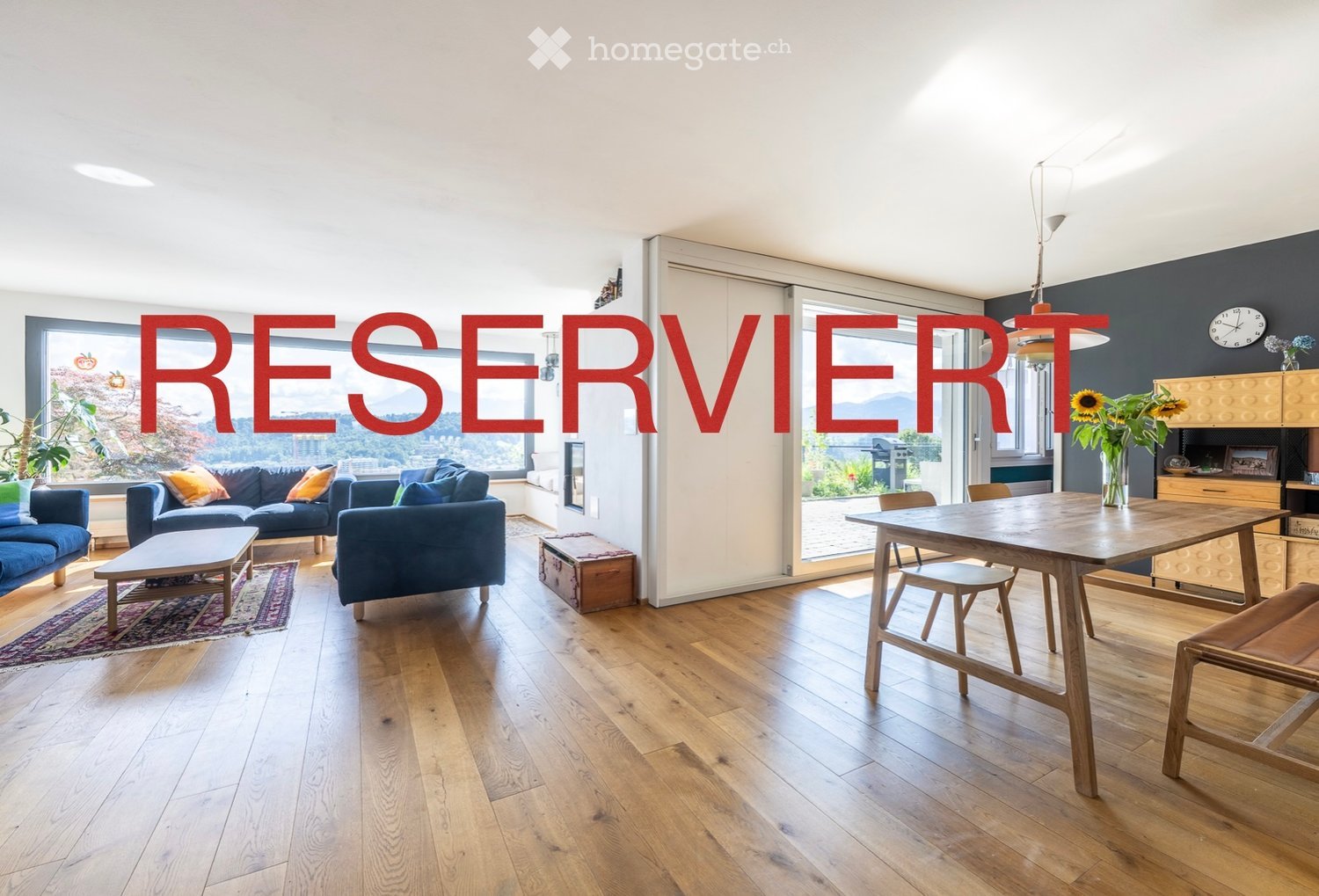 open living room with kitchen, large windows, hardwood floors, modern furniture, and a view