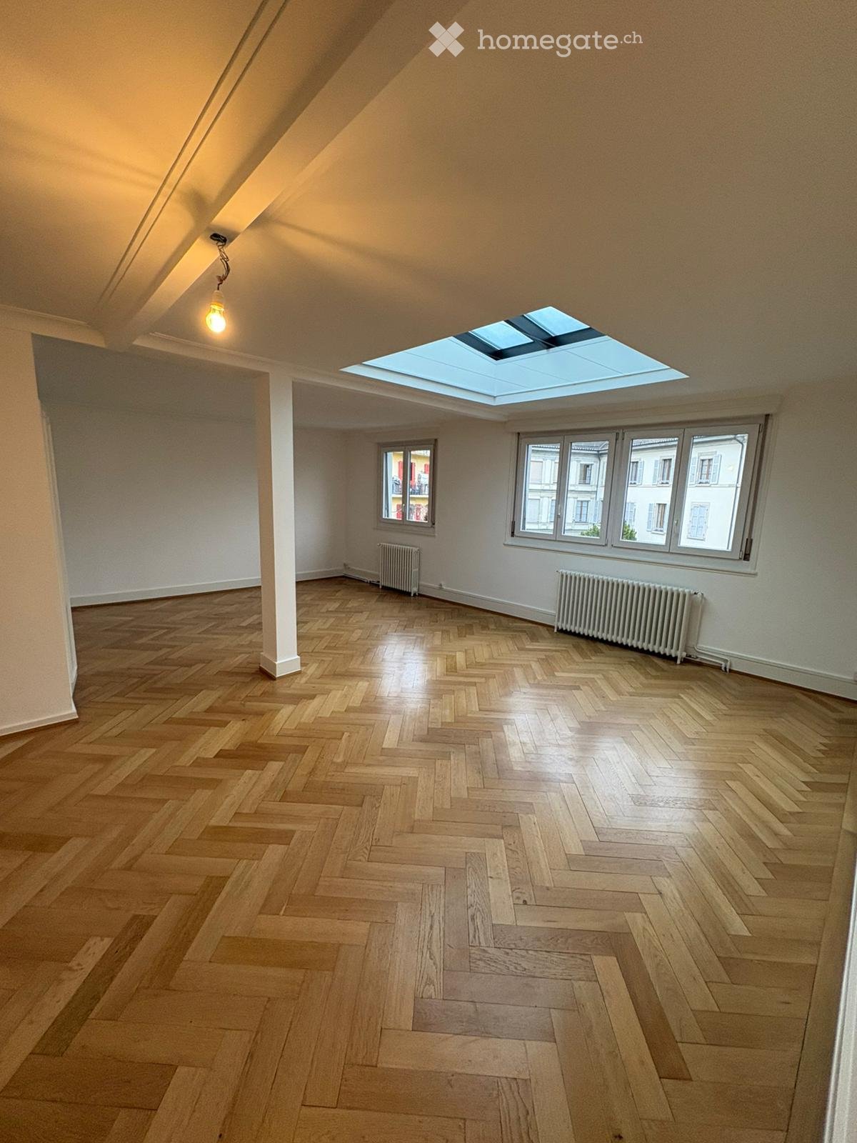 wooden floor, white walls, skylight, radiators, window with balcony