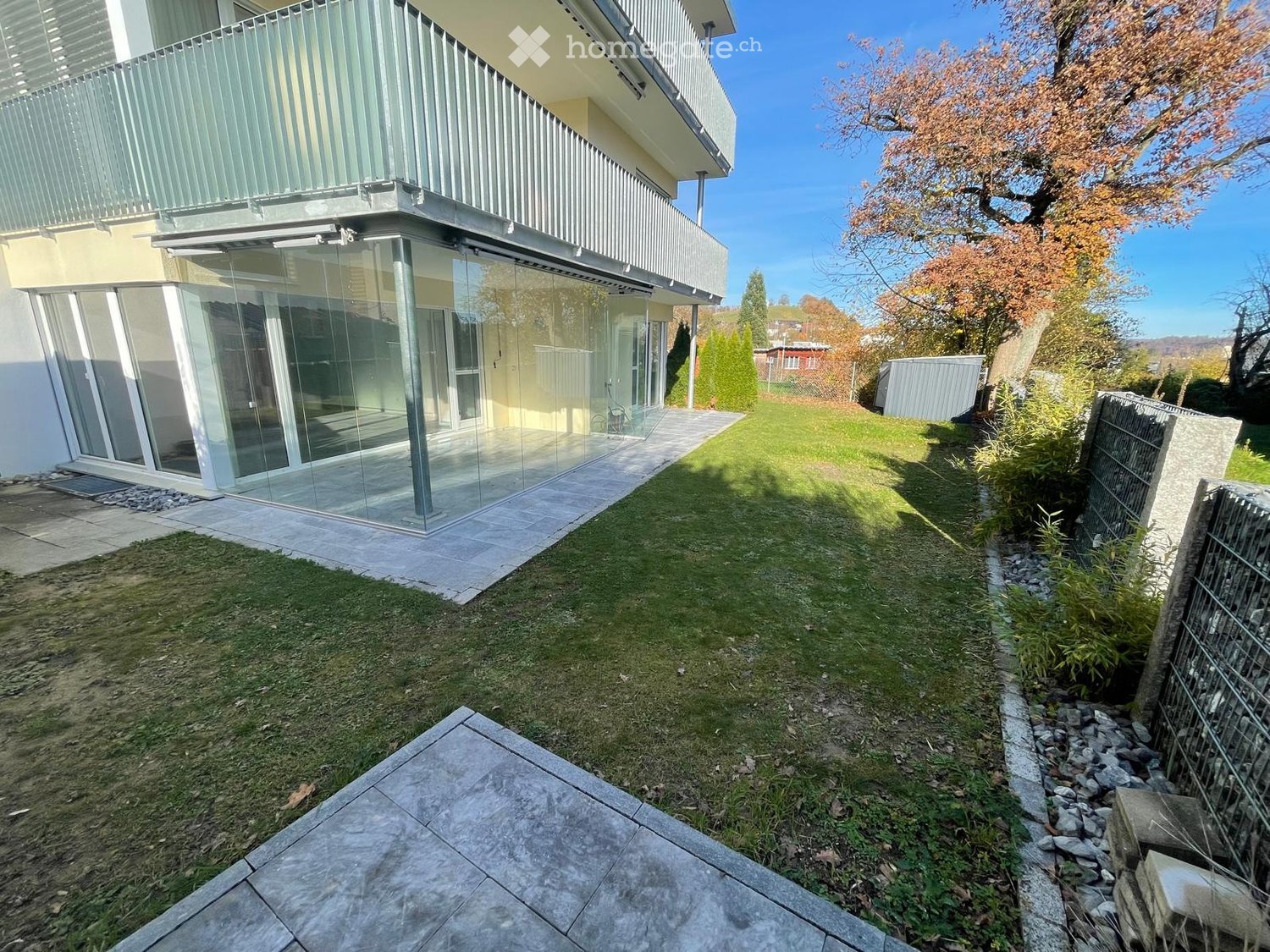 modern apartment with large terrace, glass walls, well-kept garden, stone paved pathway