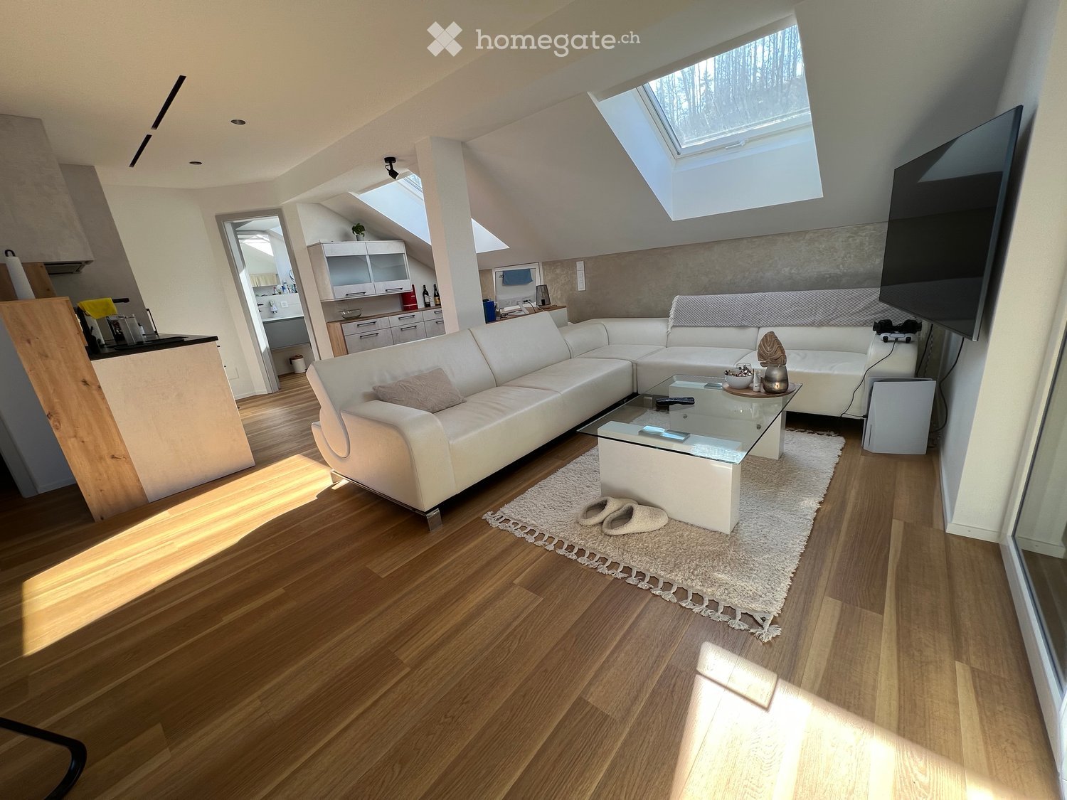 living room with a couch, coffee table, TV, and skylights