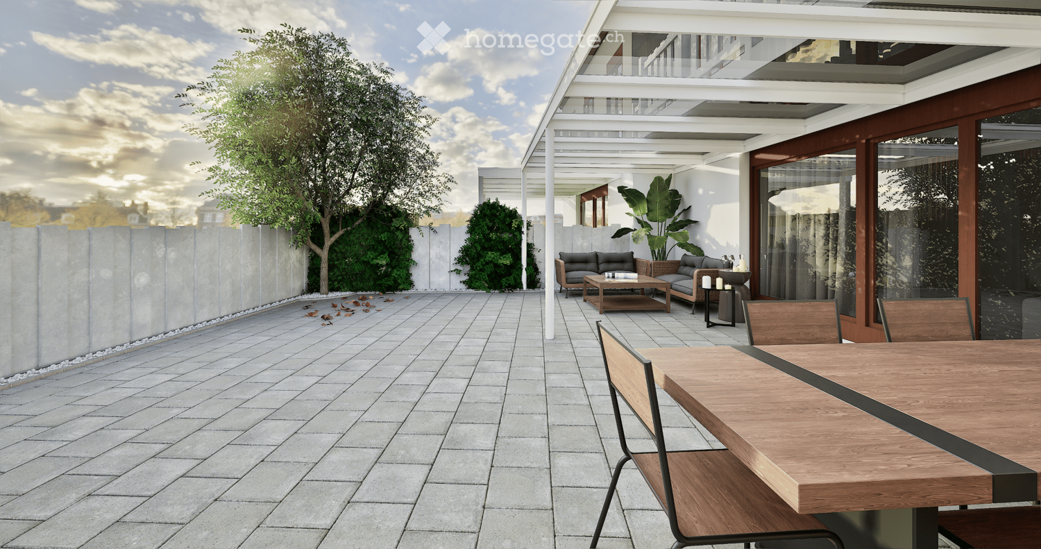 Terrace with wooden dining table, chairs, outdoor seating area with couch, coffee table, trees, shrubs, wall, and a clear sky.