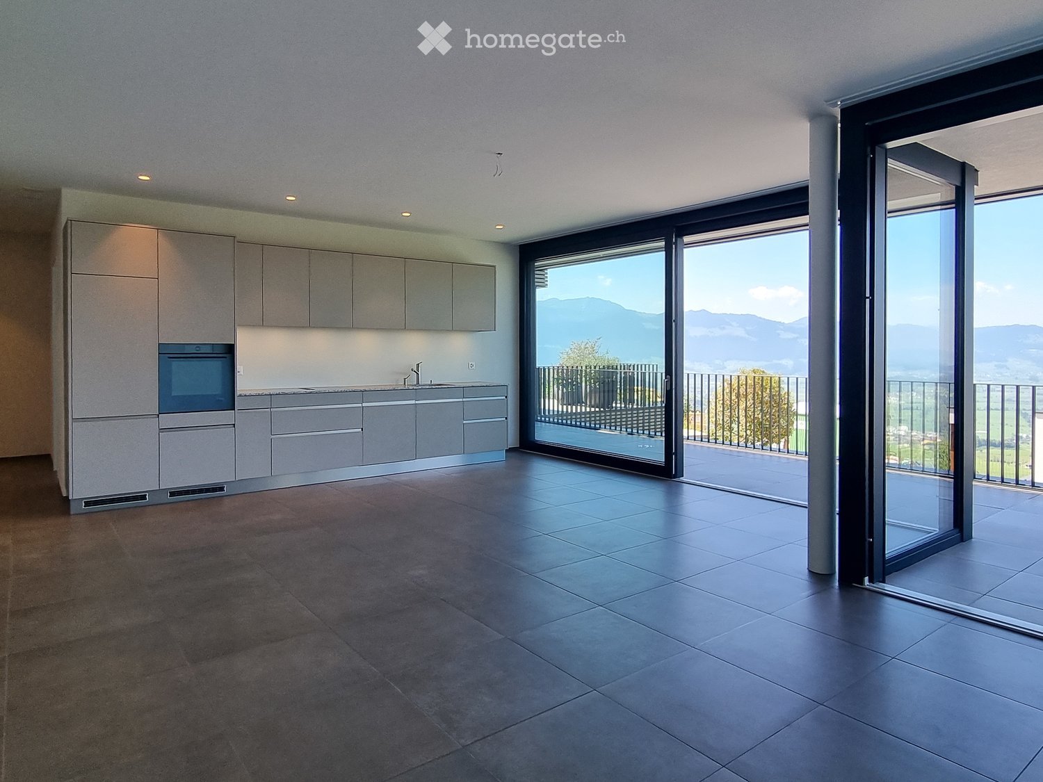 Open plan kitchen with modern appliances, wooden balcony, sliding doors with panoramic views