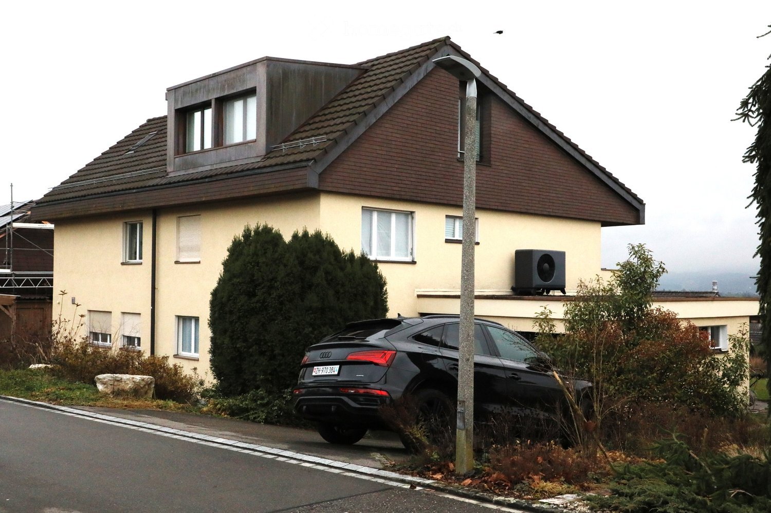 2 story house, brown roof, beige walls, windows, raised ground floor, solar panel