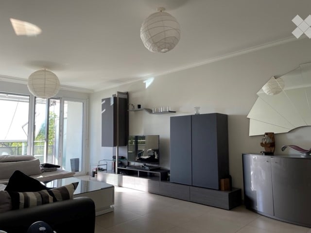 Living room, modern interior, large windows, balcony, gray furniture, tiled floor, large flat screen TV, lamp