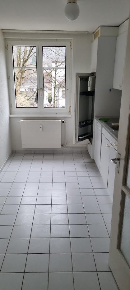 white tiles, windows, radiator, cabinets, counter, sink