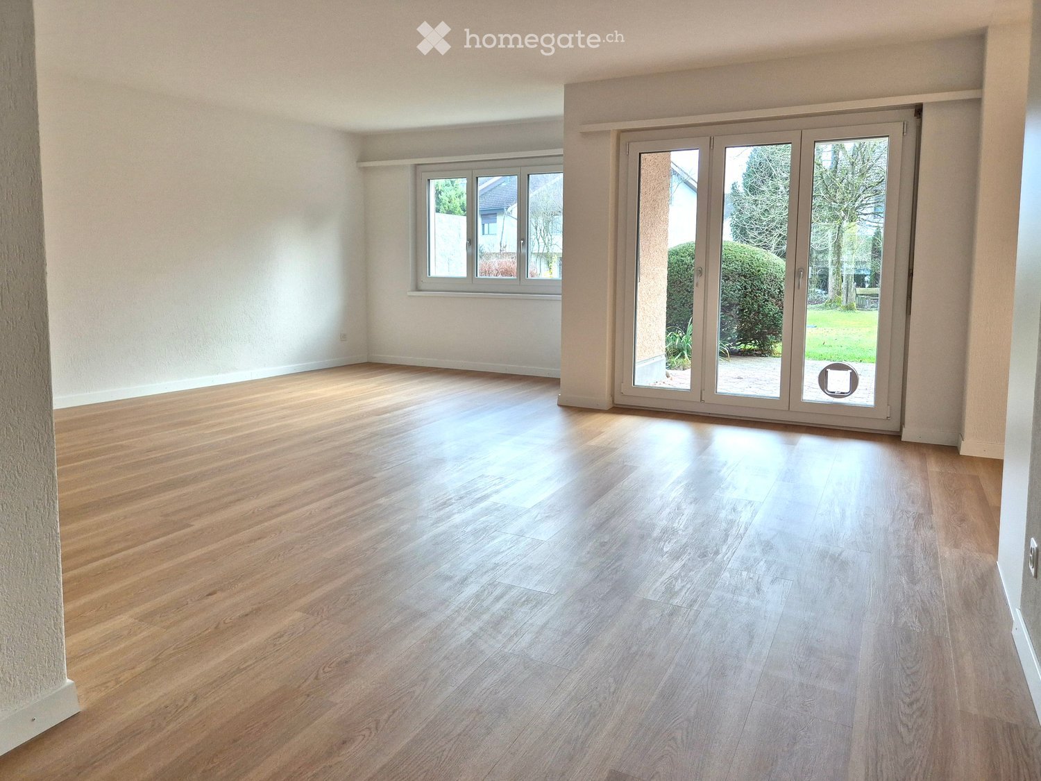 Wooden floors, sliding doors with large windows to terrace, white walls, empty room