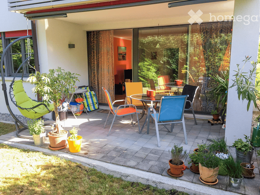 Furnished balcony with a swing, tables and chairs, round table, chairs, multiple potted plants