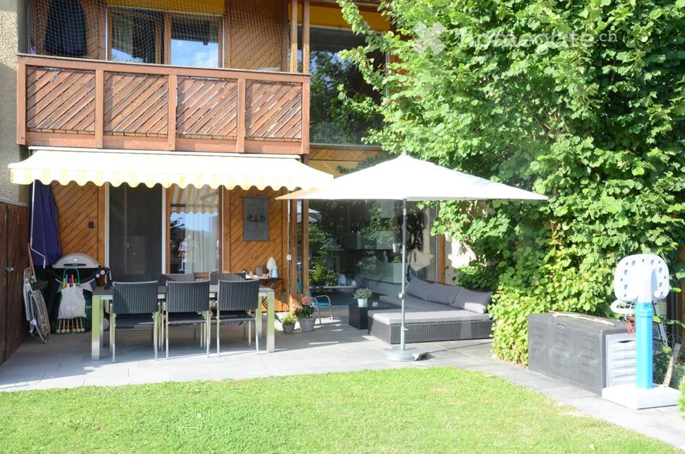 patio with dining table, chair, and canopy umbrellas, sofa, potted plants, trees, storage boxes, and a basketball net