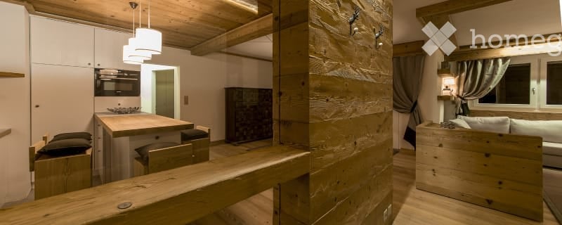wooden beams, wooden floor, wooden desk, sofa with cushions, lamp, built-in kitchen, microwave