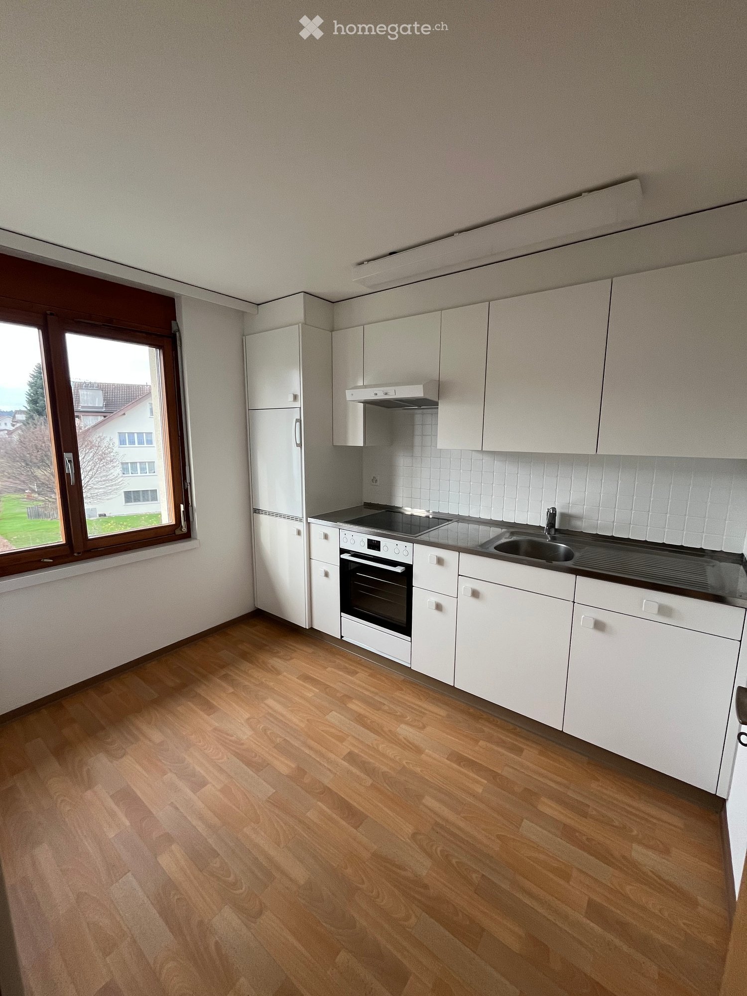 modern kitchen, white cabinets, wooden floor, stainless steel appliances, window