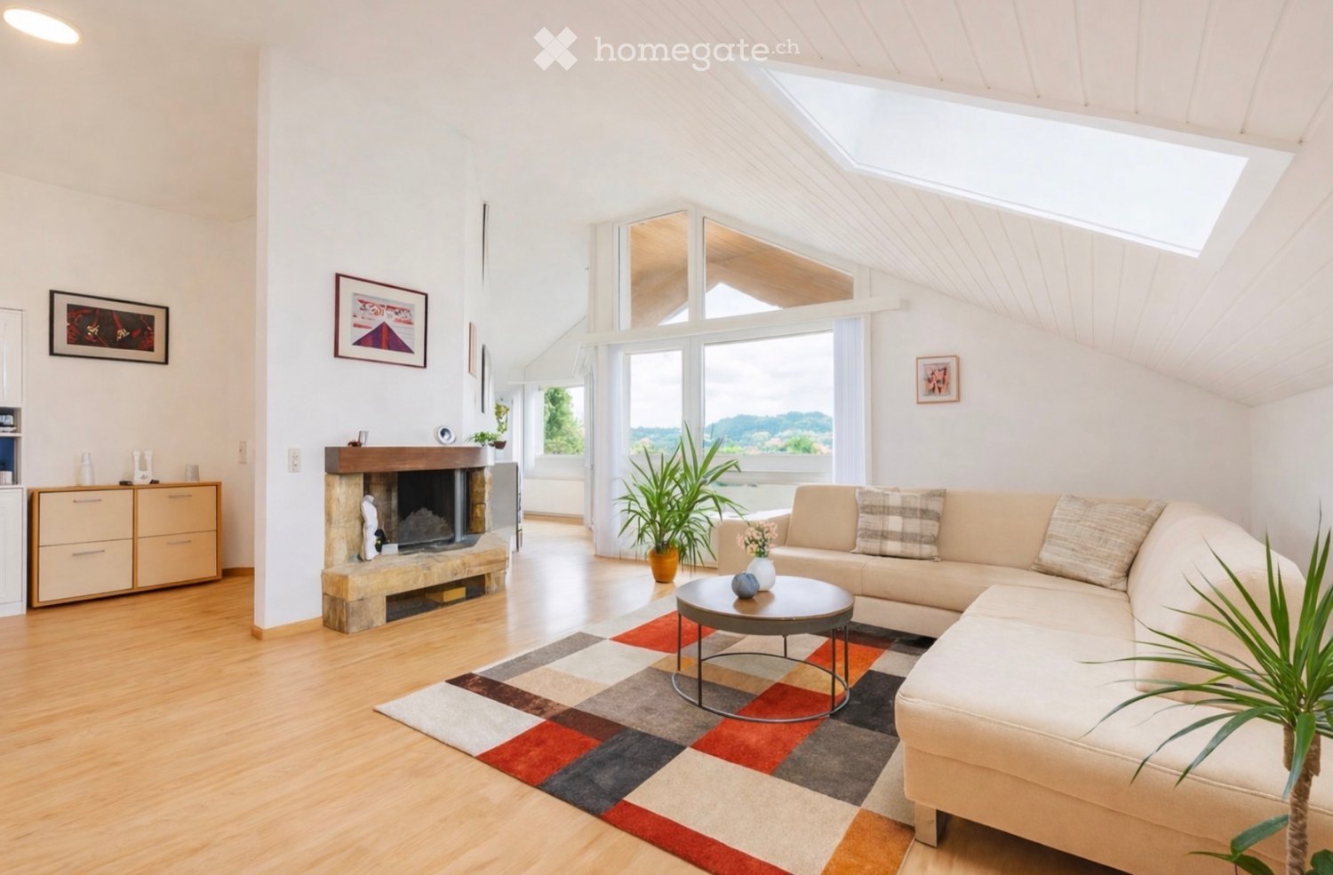 living room with white walls, hardwood floors, fireplace, couch, large windows, glass table, rug, potted plants