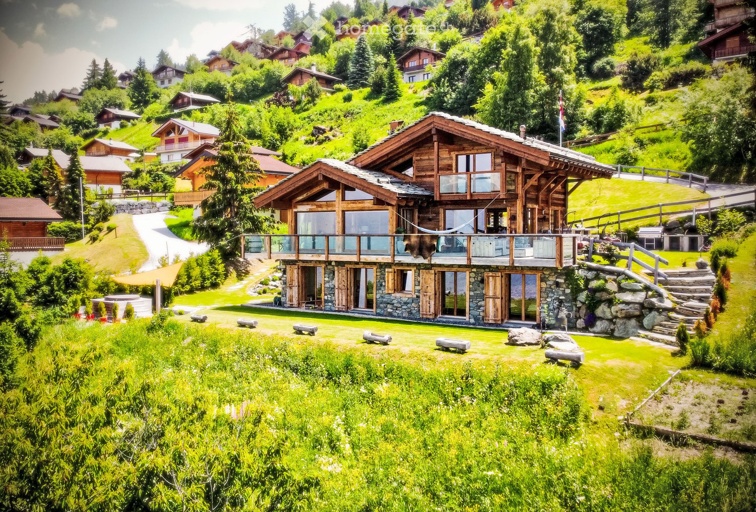 Wooden house, stone walls, large windows, elevated entrance, surrounded by trees, grass, wooden steps, green meadow