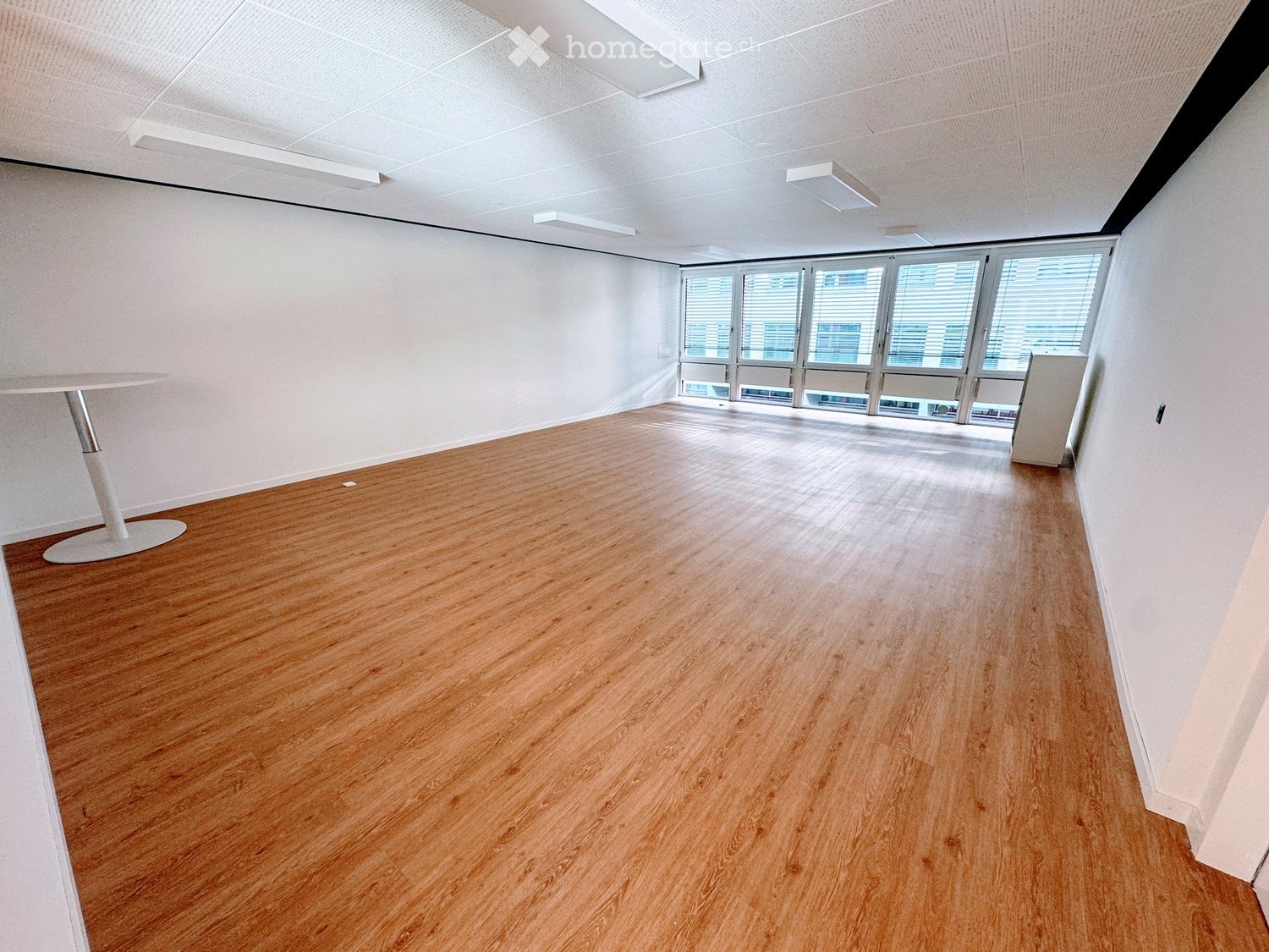 wooden floor, white ceiling, windows, small table