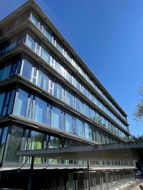 multi story office building, large windows, metallic frame, grey exterior, glass exterior