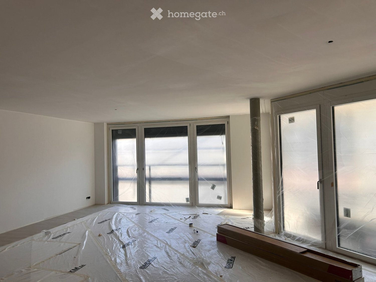 empty room, large windows, glass doors, balcony, covered with protective film