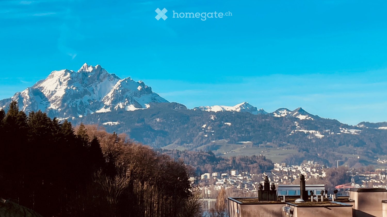 Outdoor view: mountain, city, sky, trees, lake