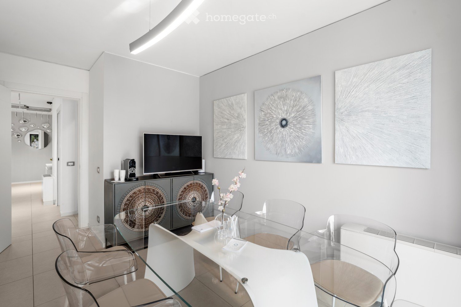modern, open concept, glass table, white chairs, white tiled floor, artwork on the wall, television, sideboard
