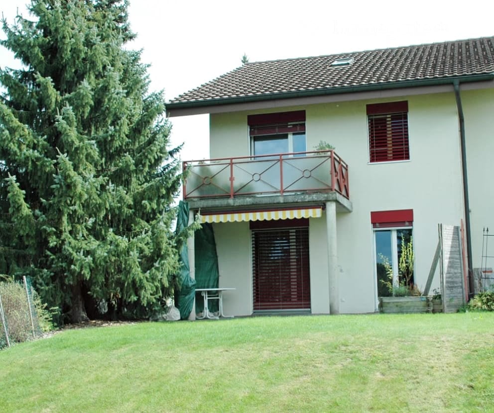 2 story house, white exterior, brown roof, balcony with red railing, large front yard, large evergreen tree