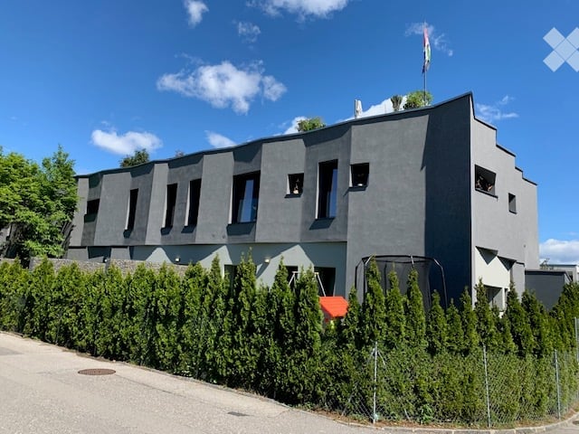 modern gray house, multiple windows, rooftop garden, surrounded by hedges