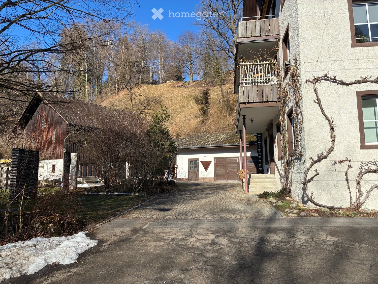 Two story house, wooden exterior, two garages, balcony, driveway