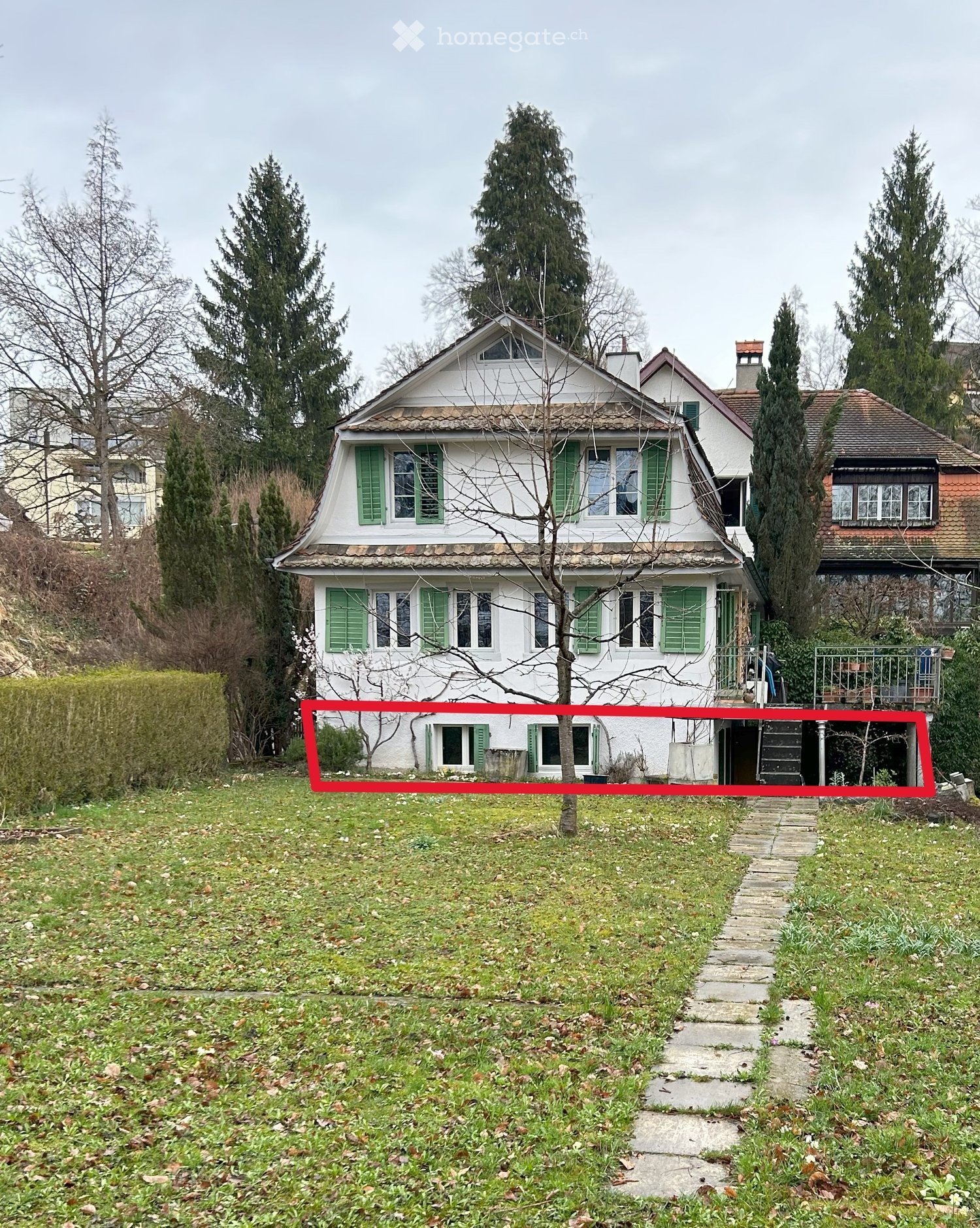 2 story house, white paint, green windows, red line indicates area for construction