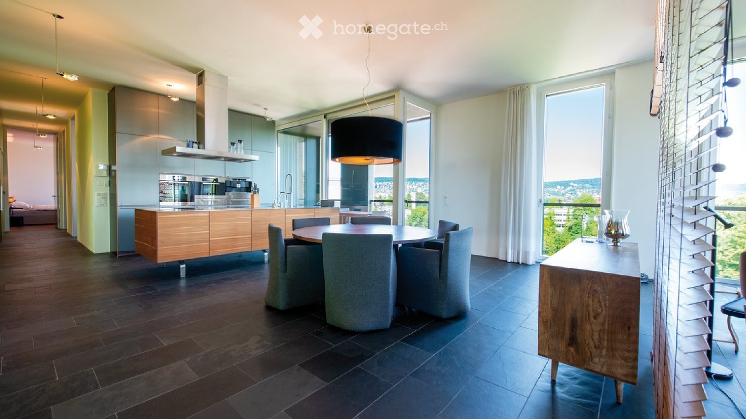modern kitchen, wooden countertops, stainless steel appliances, central dining table, large windows