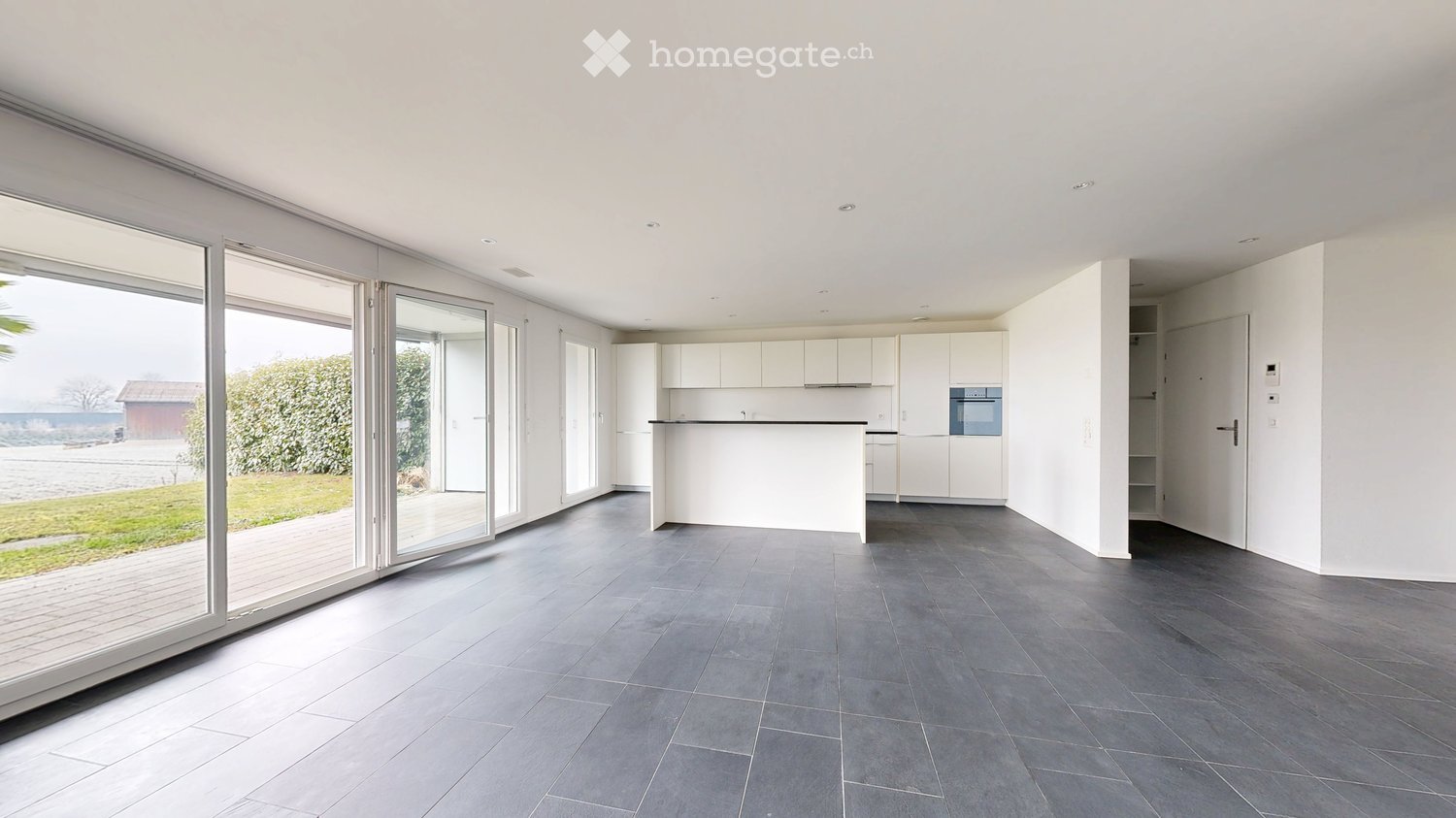 modern design, gray tile floor, kitchen island, large windows, open to outdoor deck