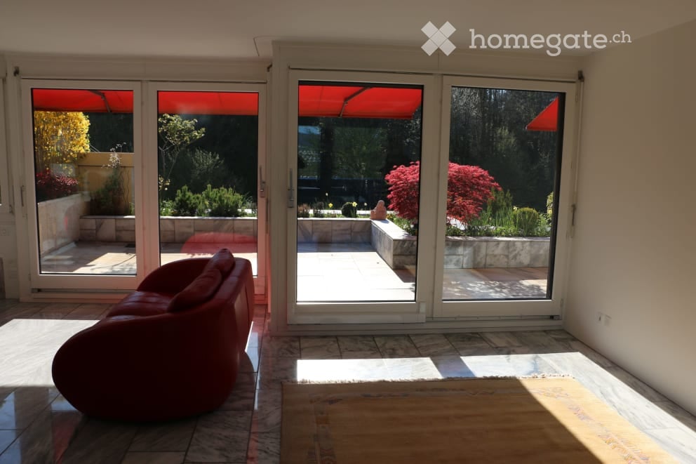 Red couch, marble floor, sliding glass doors, balcony