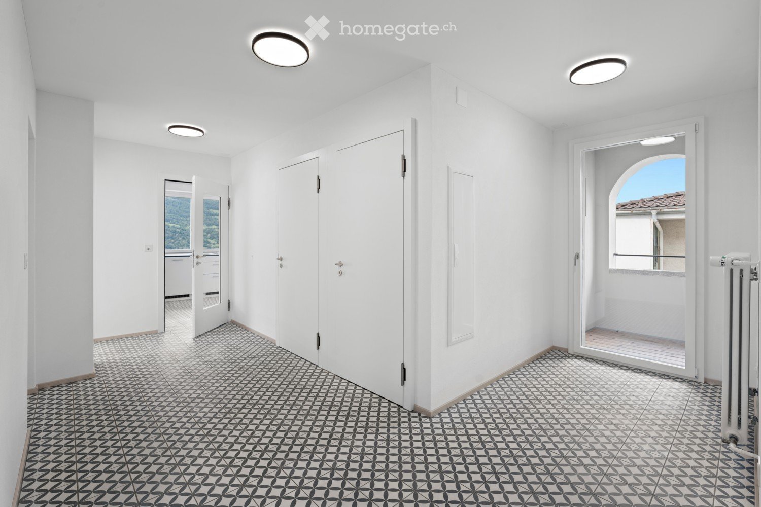empty room, white walls, patterned tile floor, round ceiling lights, door to balcony