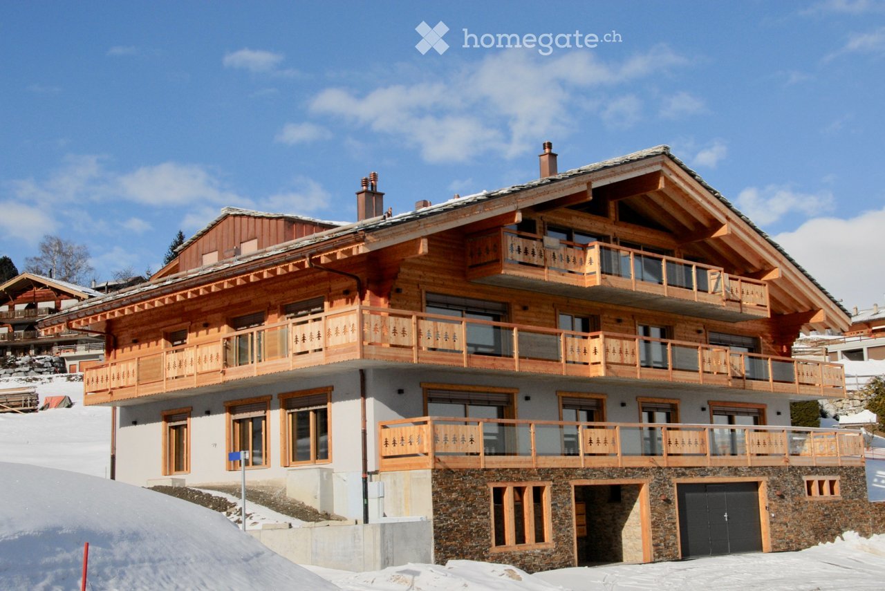 3 story chalet, wooden exterior, multiple balconies, garage, stone ground floor