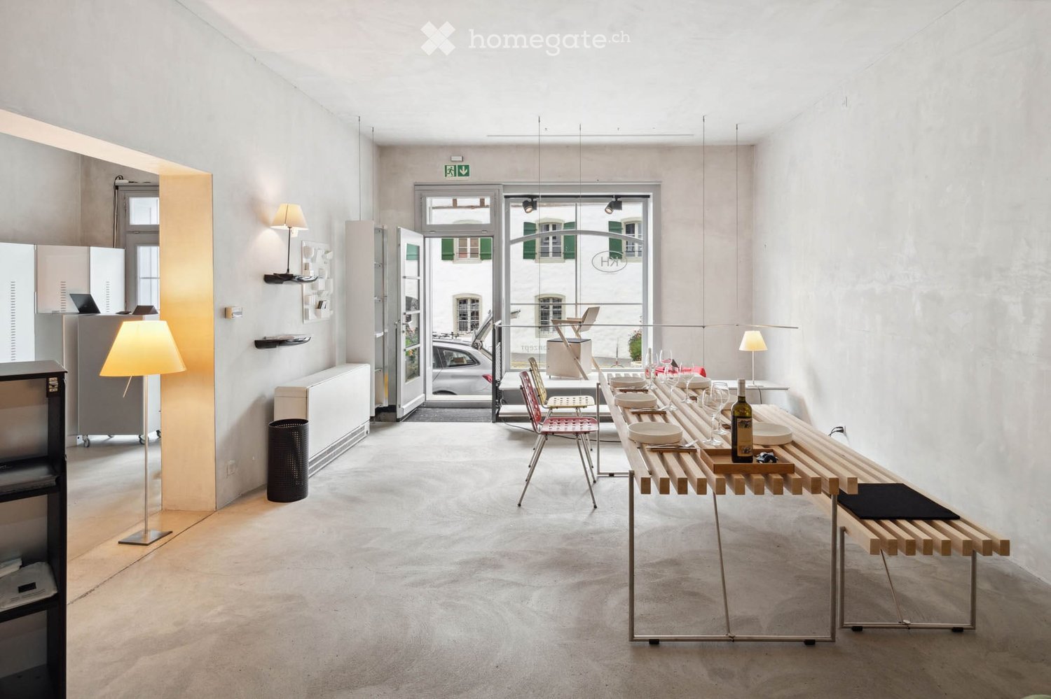 modern interior, concrete floor, white walls, large windows, open entrance, wooden dining table, chairs, open-plan