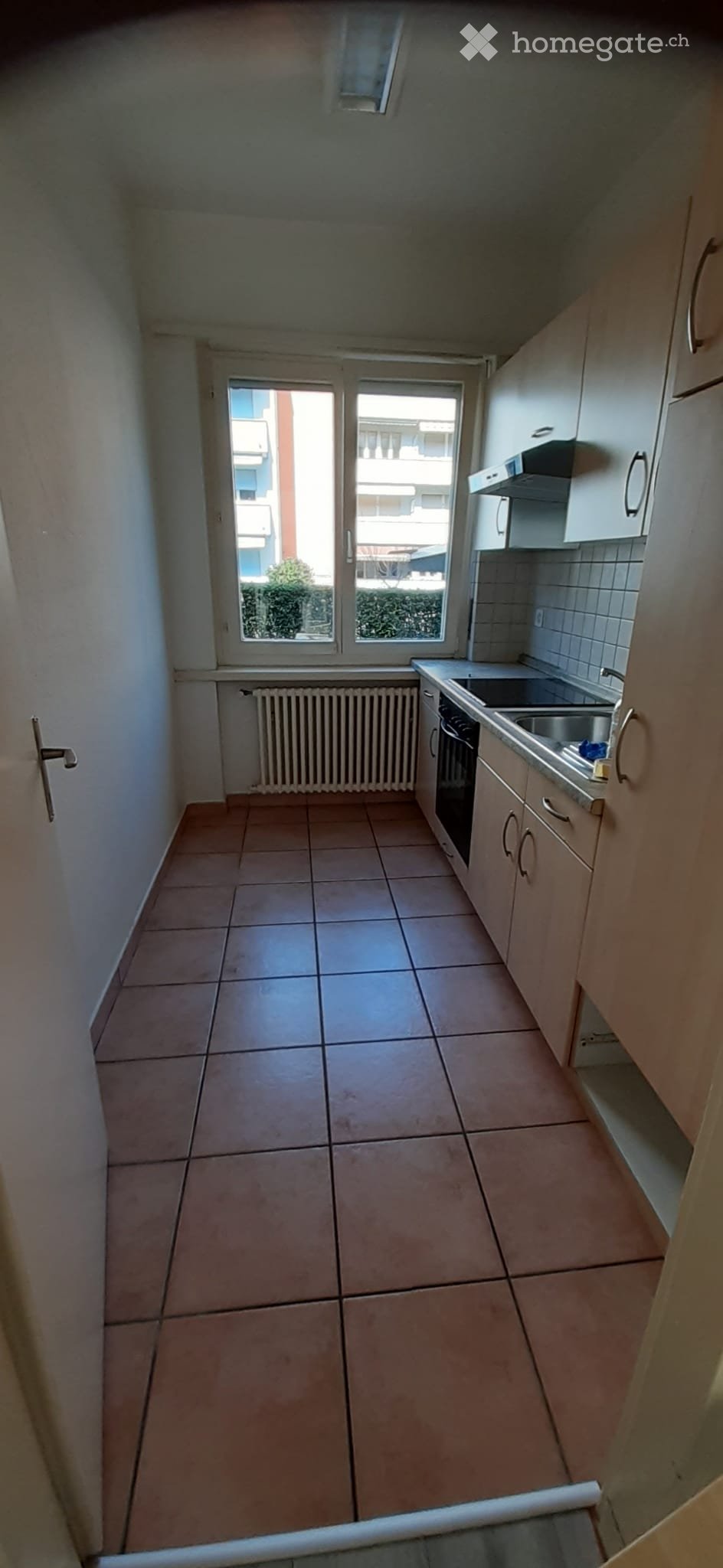 empty kitchen with tiled floor, white walls, window, cabinets, sink, stove, and a radiator