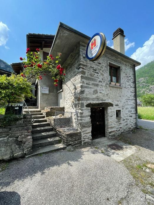 Stone house, stone steps, red flowers, sign, chimney, window, mountain view